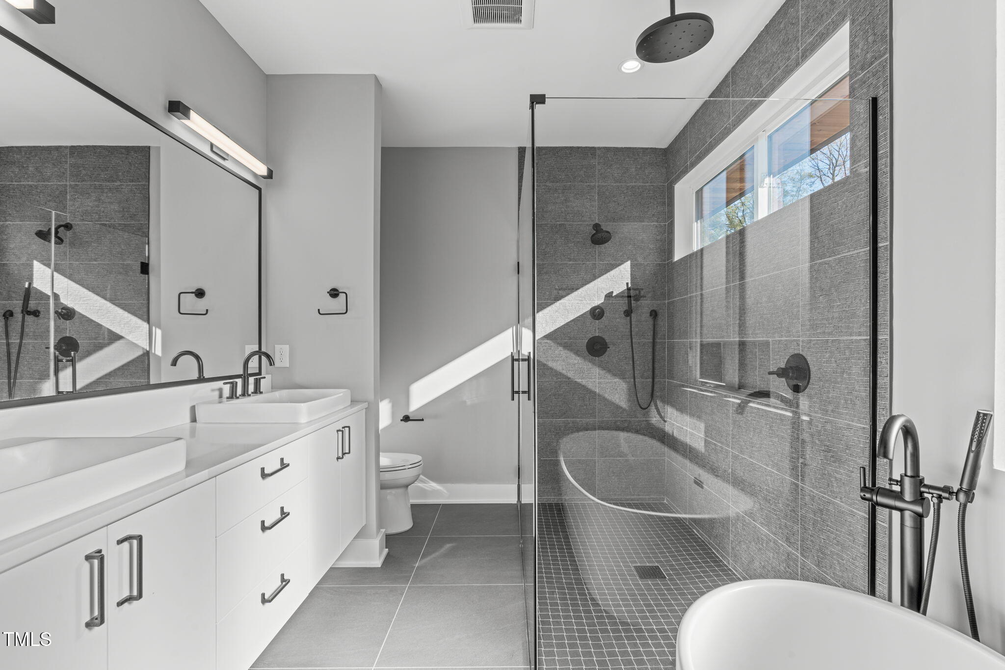 1439 Duplin Road Raleigh, NC 27607 - Photo 30 of 78 a spacious bathroom with a toilet sink and mirror