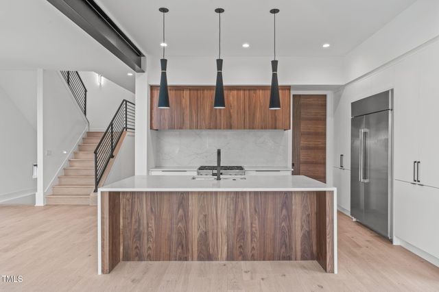 a kitchen with kitchen island granite countertop a sink stainless steel appliances and cabinets