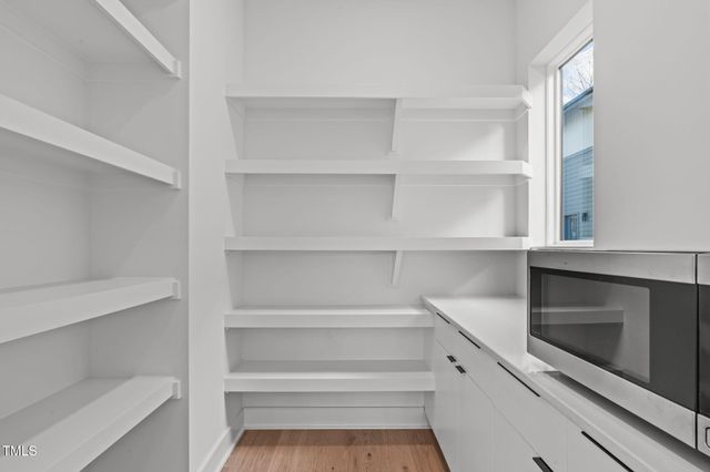 a view of a hallway with wooden floor and a fireplace