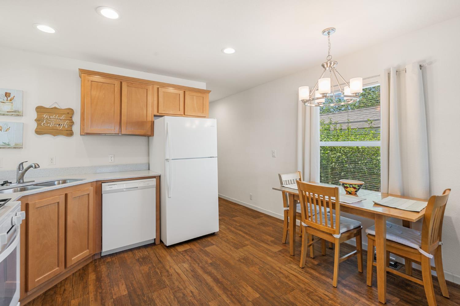 4695 Pacific Street, Unit 9 Rocklin, CA 95667 - Photo 8 of 27 a kitchen with stainless steel appliances granite countertop a table chairs and a wooden floor