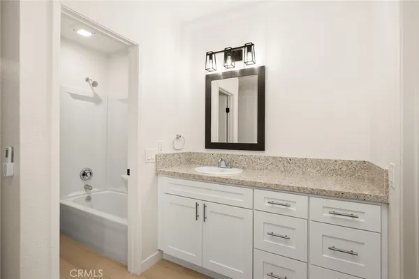 a bathroom with a granite countertop sink and a mirror