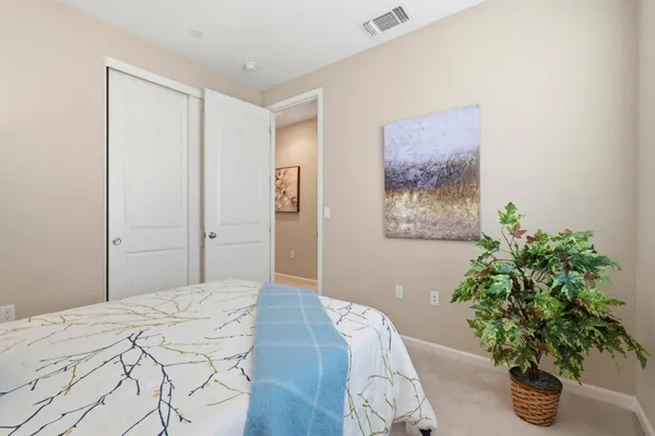 a bedroom with a large bed and a potted plant