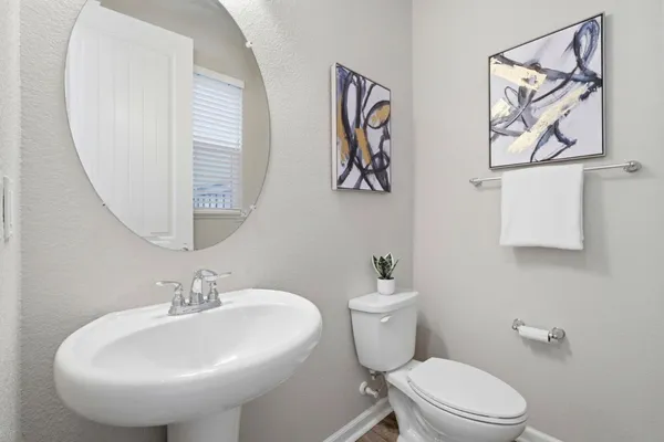 a bathroom with a toilet sink and mirror