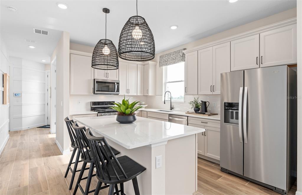 2370 Lily Bloom Road St. Cloud, FL 34771 - Photo 6 of 22 a kitchen with stainless steel appliances a dining table chairs and wooden floor