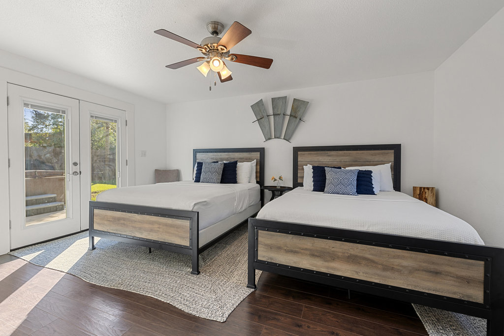 102 Ranchview Drive Johnson City, TX 78636 - Photo 25 of 37 Bedroom with access to exterior, wood finished floors, ceiling fan, french doors, and a textured ceiling