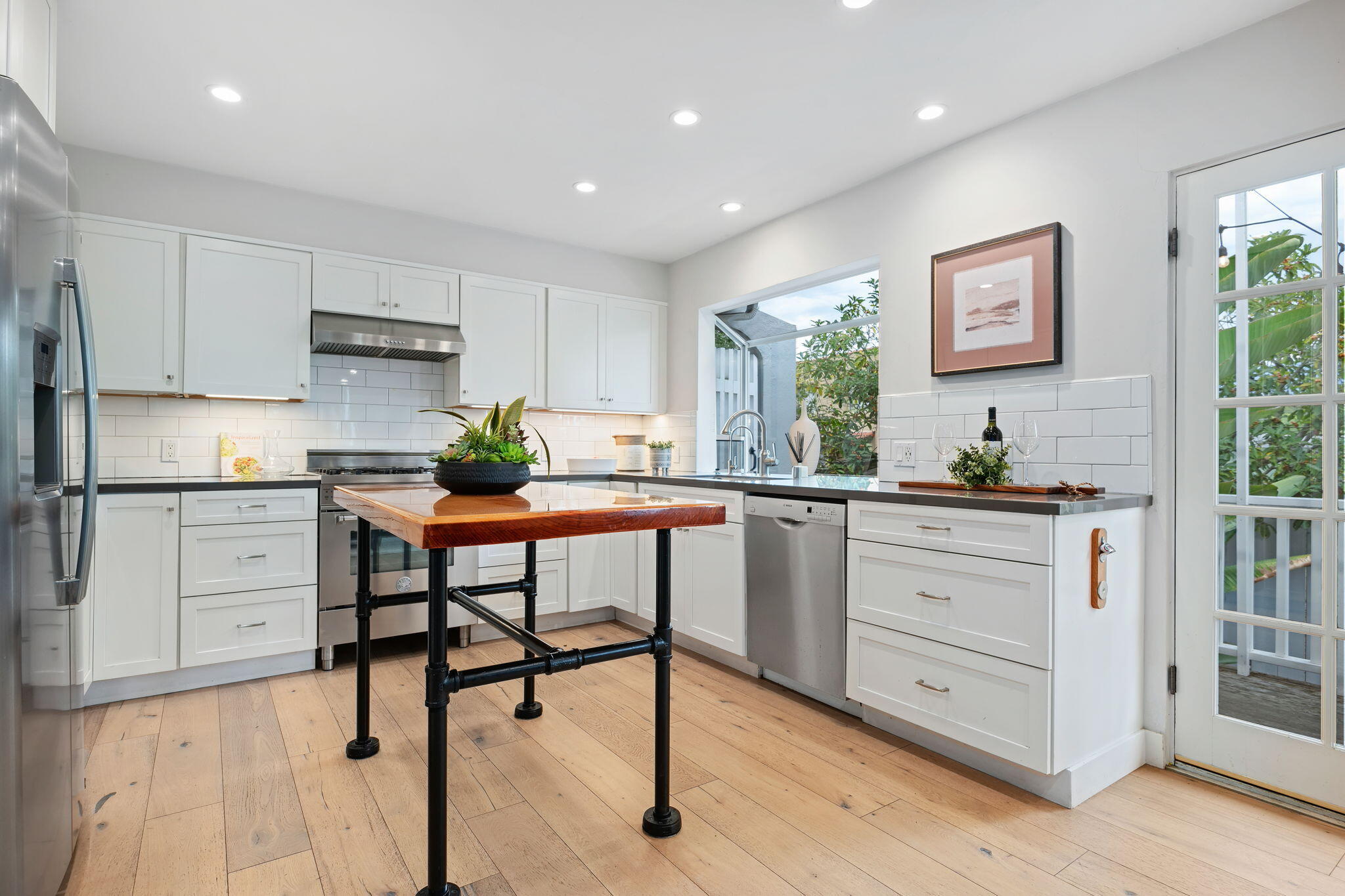 5 Fellowship Circle Santa Barbara, CA 93109 - Photo 6 of 32 a kitchen with white cabinets and appliances