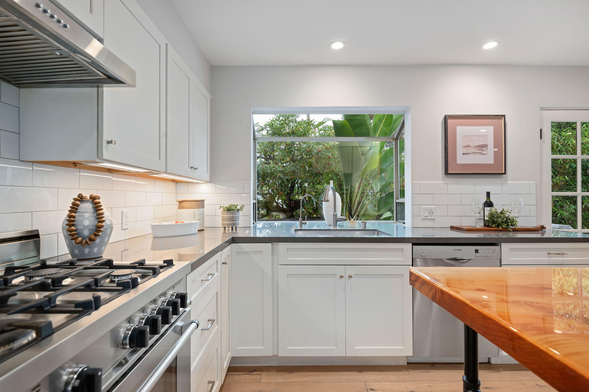 5 Fellowship Circle Santa Barbara, CA 93109 - Photo 9 of 32 a kitchen with stainless steel appliances white cabinets sink and wooden floor