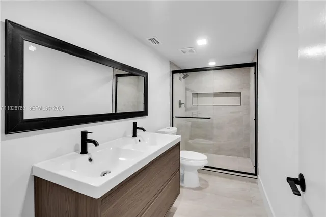 a bathroom with a sink mirror and toilet