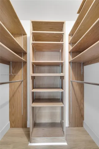 a view of walk in closet with empty racks