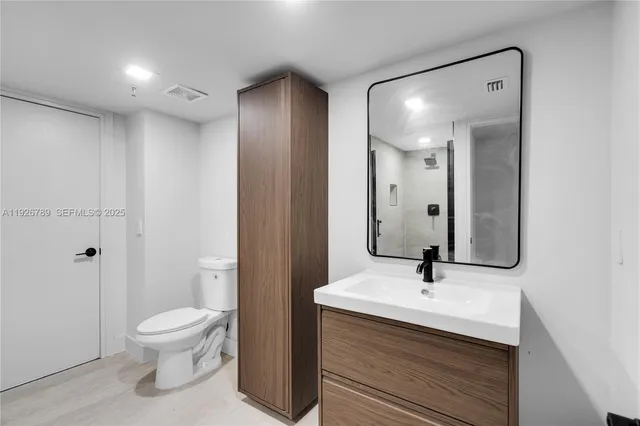 a bathroom with a toilet a sink and mirror