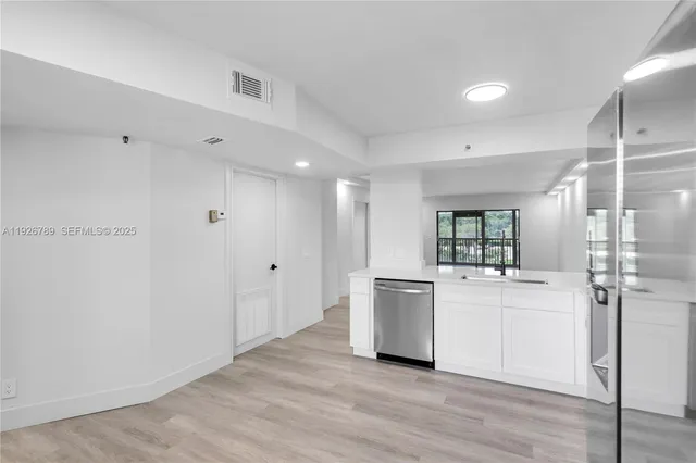 a room with a white cabinets and white appliances