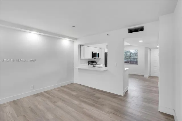 a view of a kitchen with a sink and a refrigerator