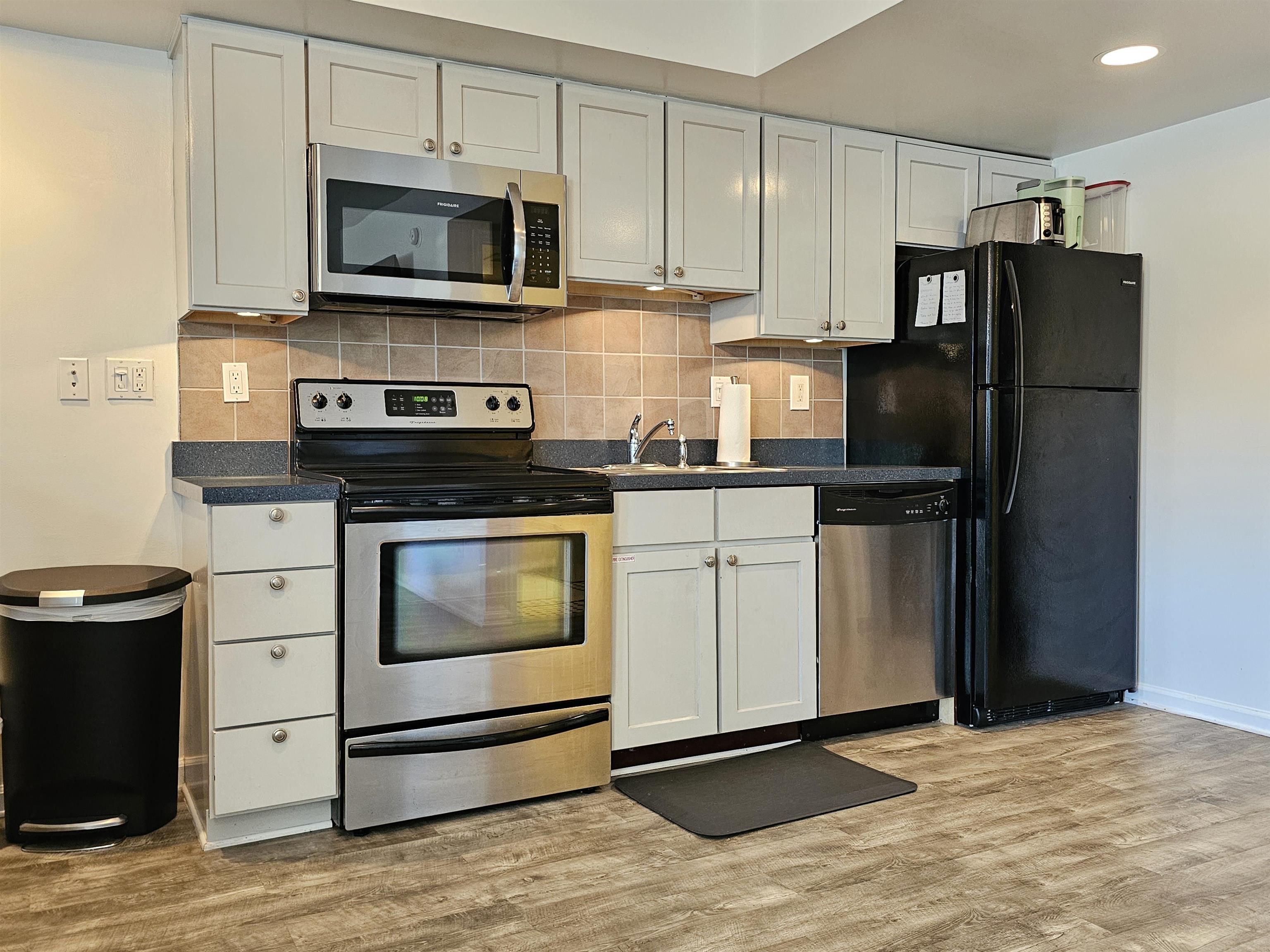 208 East Forget-Me-Not Road, Unit 101 Wildwood Crest, NJ 08260 - Photo 6 of 24 a kitchen with cabinets stainless steel appliances and wooden floor