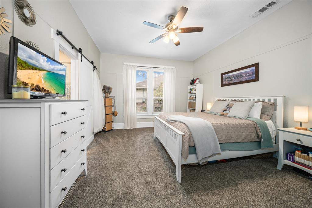 1916 Mitchell Avenue Waco, TX 76708 - Photo 26 of 32 a spacious bedroom with a bed and a flat screen tv