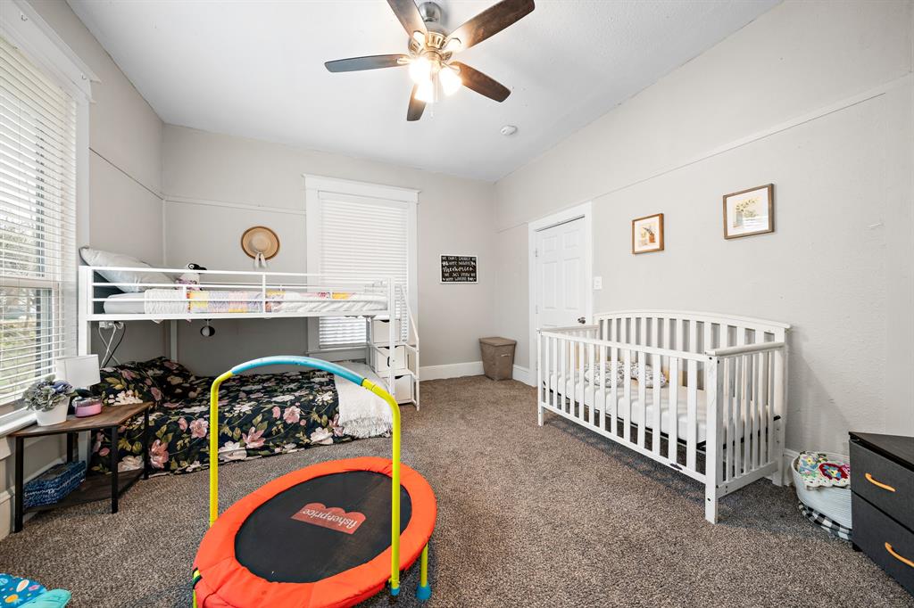 1916 Mitchell Avenue Waco, TX 76708 - Photo 30 of 32 a bedroom with a bed and a chandelier