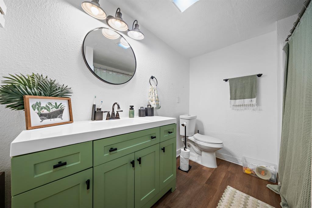 1916 Mitchell Avenue Waco, TX 76708 - Photo 31 of 32 a bathroom with a toilet sink and mirror