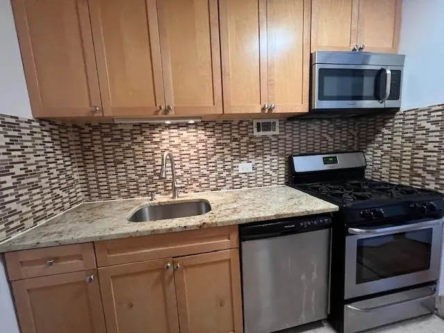 a kitchen with metallic refrigerator freezer and a dishwasher
