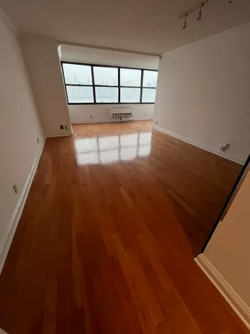 a view of a room with wooden floor and window