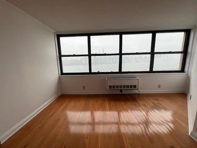 wooden floor in an empty room with a window