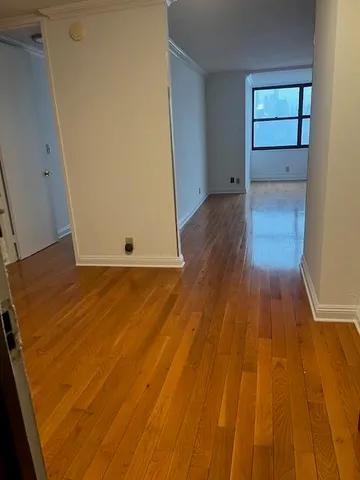 an empty room with wooden floor and entryway