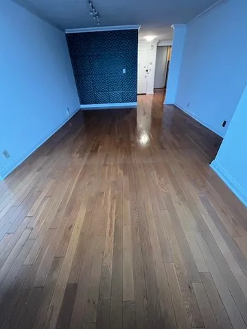 a view of a room with wooden floor and windows