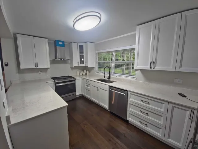 a kitchen with granite countertop white cabinets and white appliances