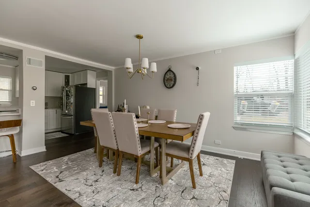 a view of a dining room and livingroom with furniture wooden floor and a rug