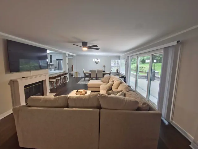 a living room with furniture a flat screen tv and a fireplace