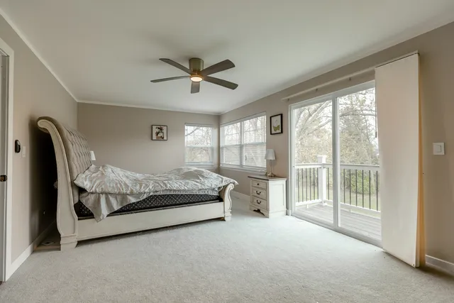 a bedroom with a large bed and a chandelier fan