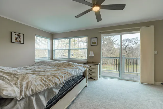 a bed sitting in a spacious bedroom next to a window