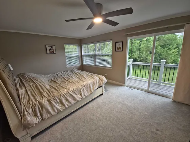 a bed sitting in a spacious bedroom next to a window