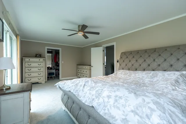 a spacious bedroom with a bed and a flat screen tv