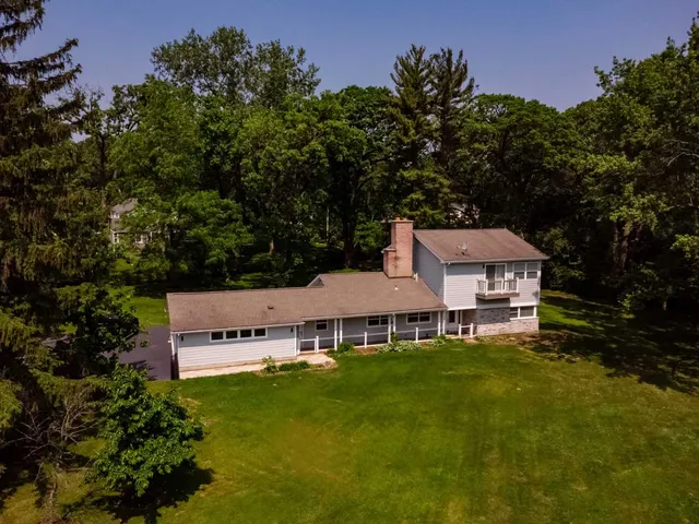 an aerial view of a house with swimming pool and garden