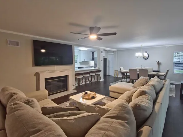 a living room with furniture a flat screen tv and a fireplace
