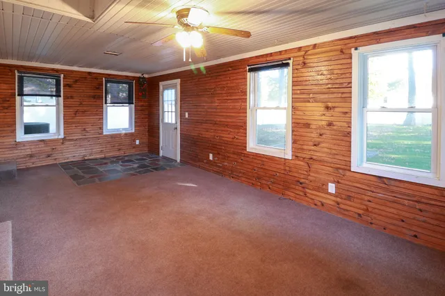 a view of a livingroom with a ceiling fan and window