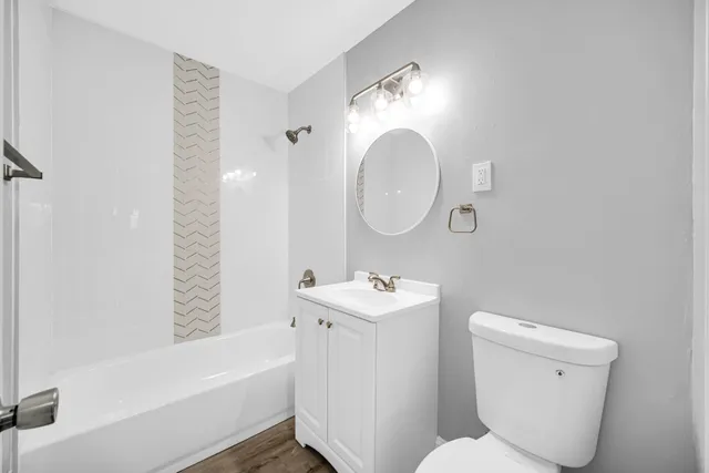 a bathroom with a toilet a sink a mirror and bathtub