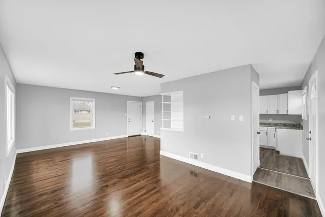 a view of empty room with wooden floor and window