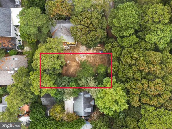 an aerial view of residential houses with outdoor space and trees