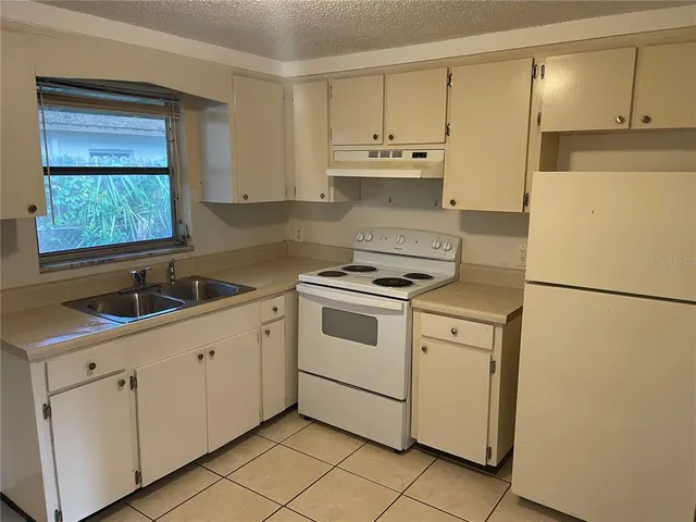 a kitchen with white cabinets and white appliances