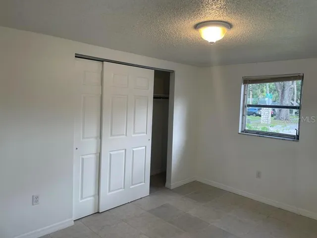 an empty room with windows and closet