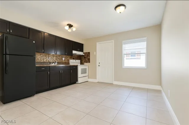 a kitchen with stainless steel appliances a sink a stove a refrigerator a window