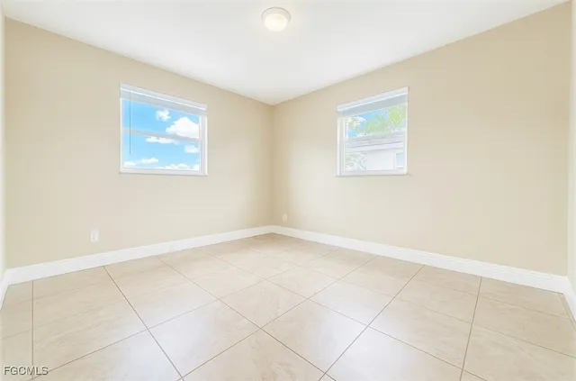 an empty room with a white wall and a window