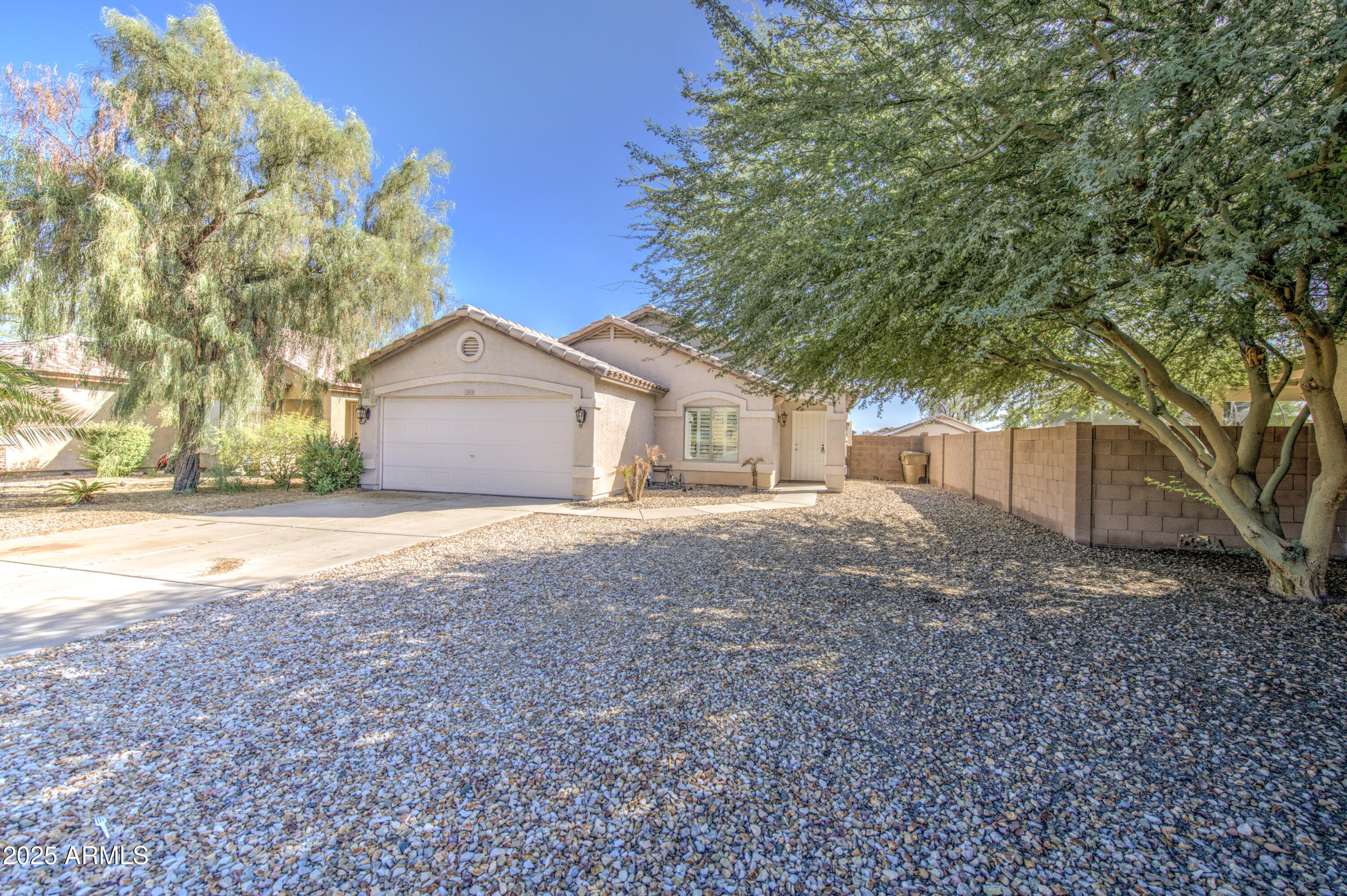 a view of a house with a yard and large tree