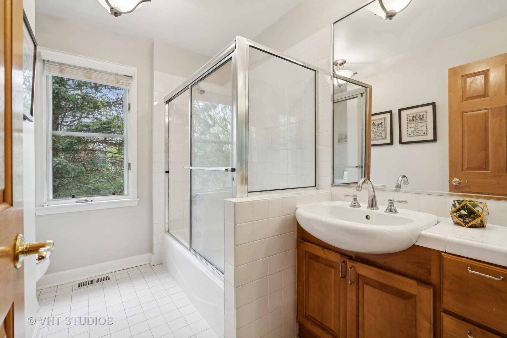 803 Hibbard Road Wilmette, IL 60091 - Photo 16 of 23 a bathroom with a sink a mirror and a shower