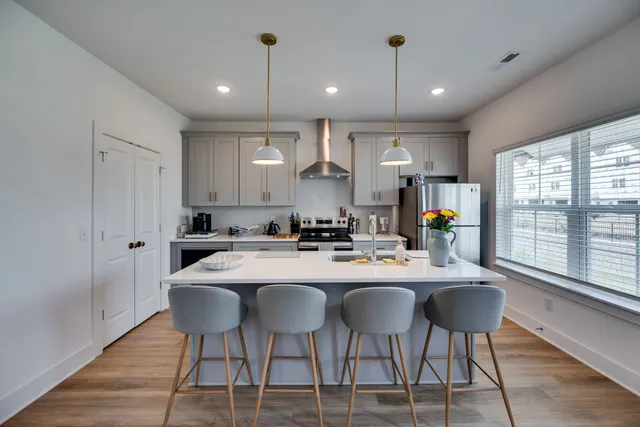 a kitchen with a dining table chairs and white cabinets