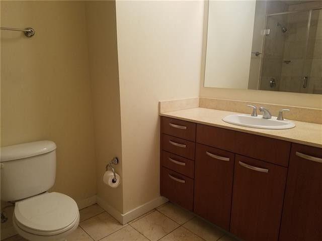 1200 Main Street, Unit 1010 Dallas, TX 75202 - Photo 11 of 13 a bathroom with a granite countertop toilet sink and mirror