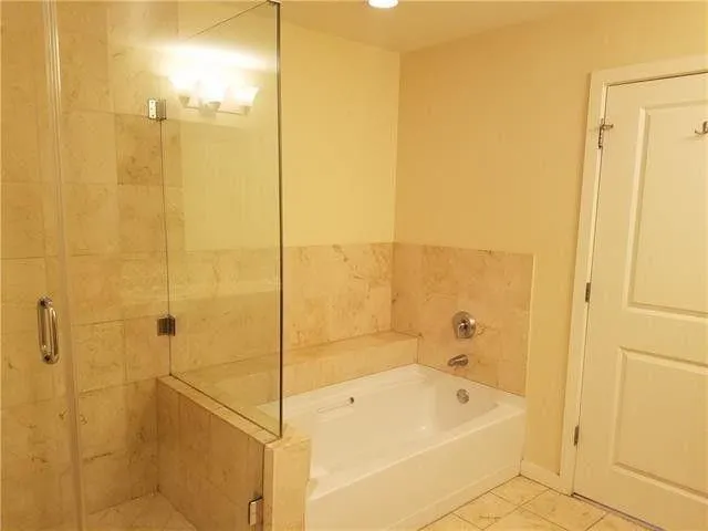 a bathroom with a tub shower and sink