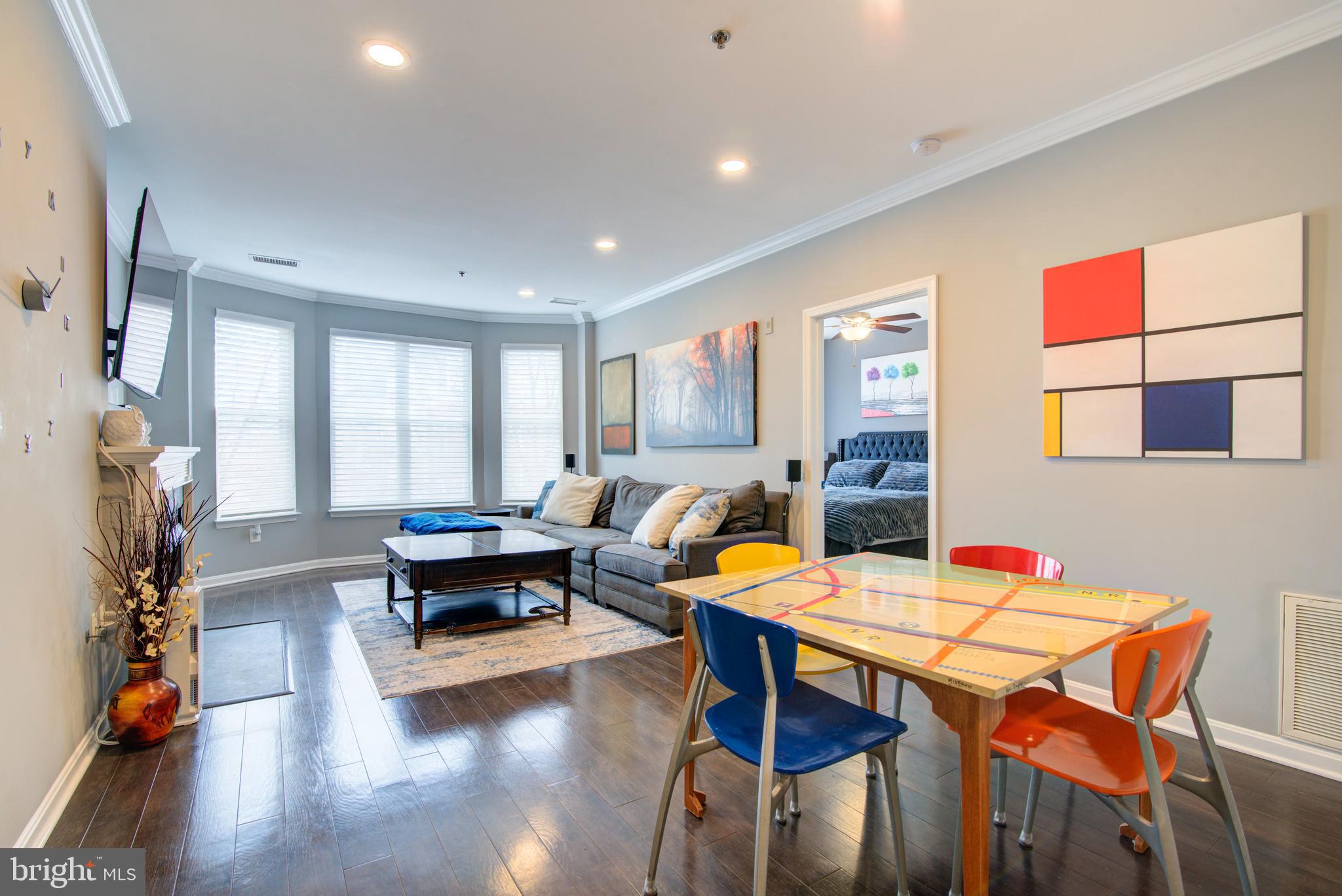 1855 Stratford Park Place, Unit 310 Reston, VA 20190 - Photo 1 of 62 a living room with furniture and wooden floor