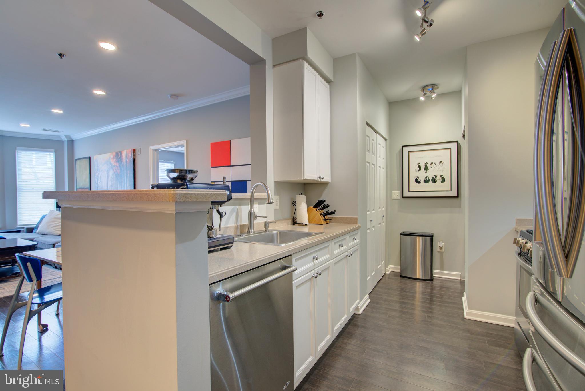 1855 Stratford Park Place, Unit 310 Reston, VA 20190 - Photo 9 of 62 a kitchen with stainless steel appliances granite countertop a refrigerator sink and wooden floor