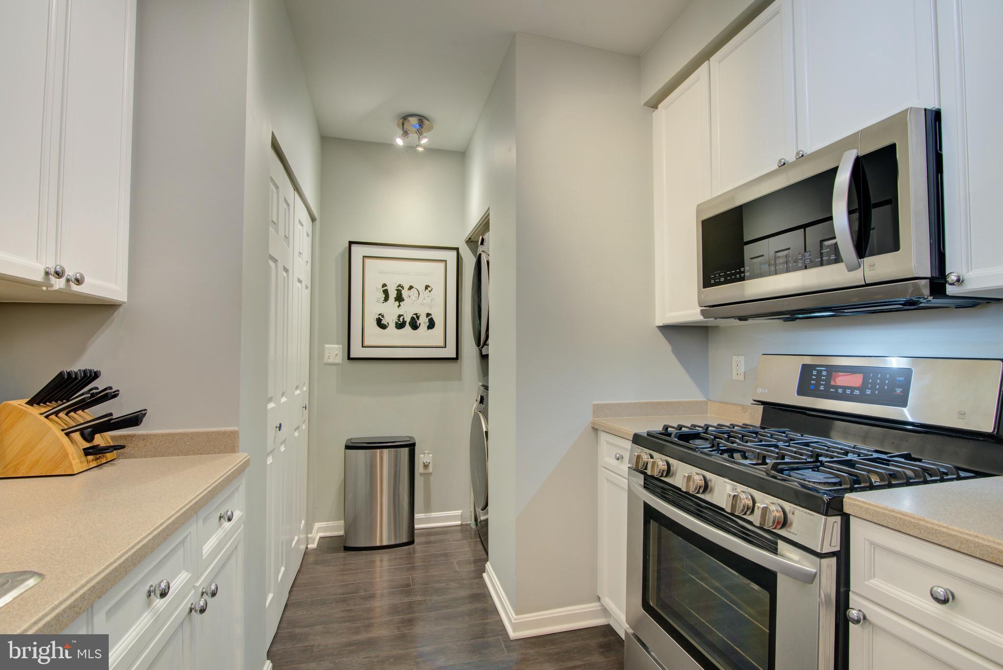 1855 Stratford Park Place, Unit 310 Reston, VA 20190 - Photo 10 of 62 a kitchen with stainless steel appliances granite countertop a stove and a microwave